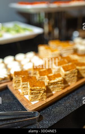 Nahaufnahme von Mini-Kuchen auf Holzbrett - süße Vorspeisen zum Buffet. Stockfoto