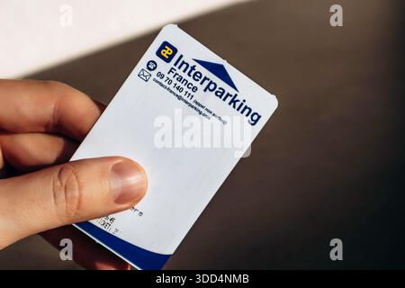 Nizza, Frankreich - 9. Dezember 2025: Nahaufnahme einer männlichen Hand, die ein Parkticket hält, ausgestellt in Nizza, Frankreich Stockfoto