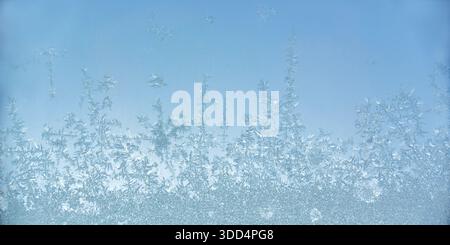 Nahaufnahme von Eiskristallen auf einer frostigen Fensterscheibe Oberfläche, eiskaltes Muster, abstrakter Hintergrund des kalten Winters Stockfoto