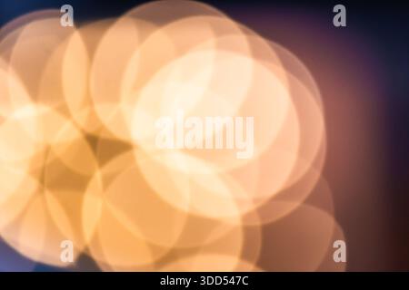 Foto von sanften orangefarbenen und gelben Bokeh-Lichtern, die einen warmen abstrakten Hintergrund bilden. Defokussierte leuchtende Kreise sorgen für eine gemütliche und elegante Stimmung, ideal für d Stockfoto
