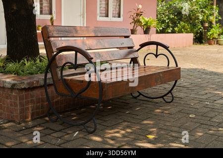 Eine einzigartige Holzbank mit Rückenlehne im Vorhof des Hauses Stockfoto