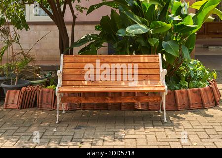 Eine klassische Holzrückenbank im Gartenbereich Stockfoto