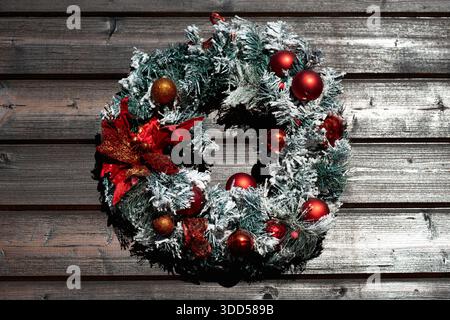 Festlicher Weihnachtskranz an einer dunklen Holztür Stockfoto