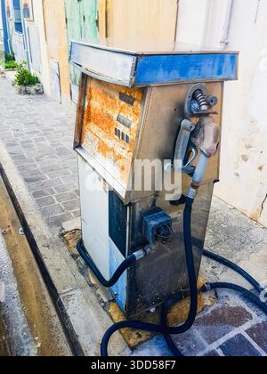 Alte, rostige und kaputte Benzinpumpe am Straßenrand in Malta. Stockfoto