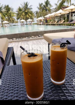 Zwei Gläser vietnamesischer Kaffee auf einem Tisch neben dem Hotelpool, Hoi an, Vietnam Stockfoto