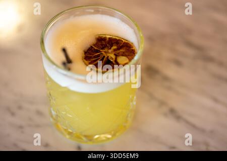 Nahaufnahme eines erfrischenden gelben Zitronencocktails mit Eis und Zitrusduft im Glas Stockfoto