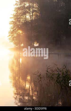 Ein wunderbarer Blick auf die herbstliche Natur: Verbrennender Nebel und das aufgehende Sonnenlicht über dem See. Trakai, Litauen Stockfoto