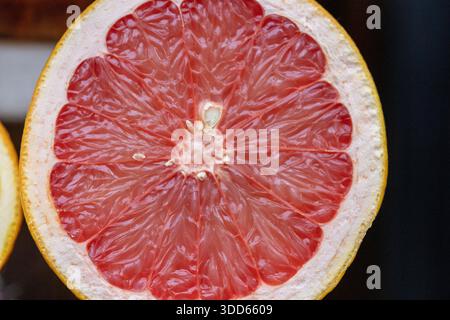 Nahaufnahme einer saftigen halbierten rosafarbenen Grapefruit mit reichhaltiger Textur von Zitrusfleisch Stockfoto