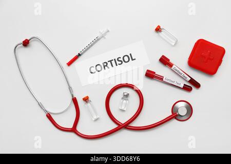 WORTCORTISOL mit Stethoskop, Ampullen und Blutproben auf grauem Hintergrund. Medizinisches Konzept Stockfoto