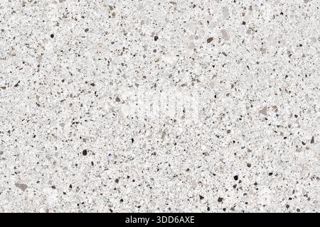 Hochauflösende Ansicht einer weißen Terrazzo- oder Quarzoberfläche. Modernes Baumaterial mit einer Mischung aus grauen, schwarzen und beigen Mineralsteinen Stockfoto