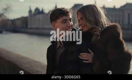 Ein romantisches Paar umarmt an einem sonnigen Tag Paris Frankreich mit der seine und den Stadtgebäuden im Hintergrund. Dieses Bild ist für Reisen geeignet Stockfoto