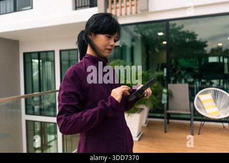 Frau, die im Freien ein digitales Tablet verwendet und sich mit der Technologie für Fernarbeit vernetzt Stockfoto