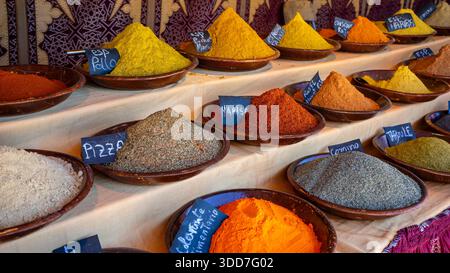 Bunte Gewürze in Schüsseln auf einem Tisch angeordnet Stockfoto