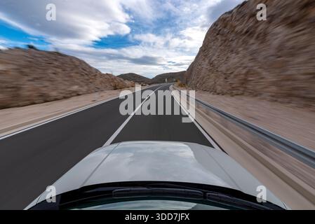 Ein Auto, das auf offener Straße schnell fährt Stockfoto