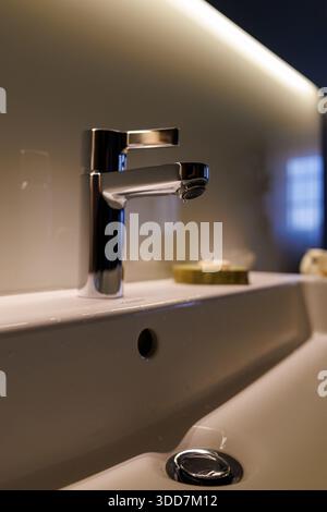 Ein elegantes, modernes Badezimmer mit minimalistischem Waschbecken und Wasserhahn. Stockfoto