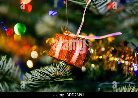 Nahaufnahme eines wunderschön dekorierten Weihnachtsbaums mit lebendigen Ornamenten und funkelnden Lichtern. Der Fokus liegt auf zwei schimmernden Kugeln – einer aus Gold und Stockfoto