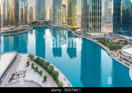 Moderne Skyline am Wasser mit luxuriösen Wolkenkratzern und türkisfarbenem Kanal in Dubai, Vereinigte Arabische Emirate. Stockfoto
