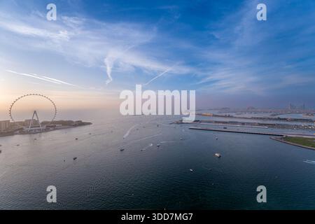 Blick auf den Arabischen Golf bei Sonnenuntergang mit dem Ain Dubai Aussichtsrad und den Dubai Inseln von oben Stockfoto
