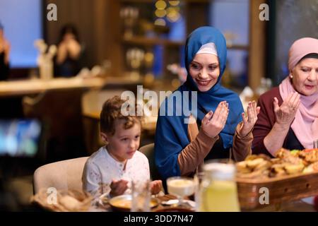 Die muslimische Familie genießt iftar gemeinsam in einem Restaurant, das für Ramadan-Feiern eingerichtet ist Stockfoto