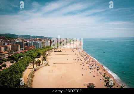 Blick aus der Vogelperspektive auf einen überfüllten Strand mit Stadtblick Stockfoto