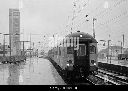 Sechzigerjahre, 20.12.1965, Deutschland, Hauptbahnhof Essen, Ruhrgebiet, Rheinland, Nordrhein-Westfalen, NRW, Personenzug faehrt ab in Richtung Bochum und Dortmund, der Bahnsteig ist menschenleer, links ein Verwaltungshochhaus Sechzigerjahre, 20.12.1965, Deutschland, Hauptbahnhof in Essen, Ruhrgebiet, Rheinland, Nordrhein-Westfalen, NRW, Personenzug faehrt ab in Richtung Bochum und Dortmund, der Bahnsteig ist menschenleer, links ein Verwaltungshochhaus, Sixties, 20.12.1965, Deutschland, Hauptbahnhof Essen, Ruhrgebiet, Rheinland, Nordrhein-Westfalen, NRW, der Passagierzug verlässt die Stati Stockfoto