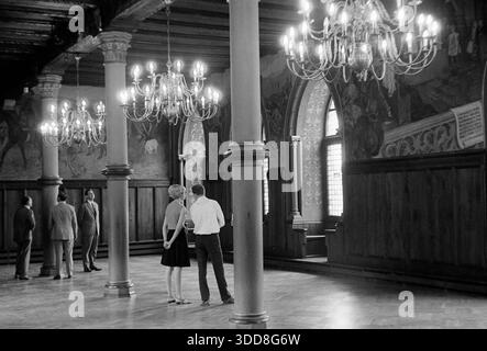 Sechzigerjahre, 26.08.1967, Deutschland, Solingen, Solingen-Burg an der Wupper, Bergisches Land, Rheinland, NRW, Schloss Burg, Stammsitz der Grafen und Herzoege von Berg, Innenaufnahme, Touristen bestaunen den Rittersaal mit Saeulen und Kronleuchtern Sechzigerjahre, 26.08.1967, Deutschland, Solingen, Solingen-Burg, Stadtteil Burg an der Wupper, Bergisches Land, Rheinland, Nordrhein-Westfalen, NRW, Schloss Burg, Stammsitz der Grafen und Herzoege von Berg, Innenaufnahme, Touristen bestaunen den Rittersaal mit Saeulen und Kronleuchtern, Maenner und Frau, Sechzigerjahre, 26.08.1967, Deutschland, Solingen, So Stockfoto