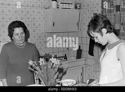 Sechzigerjahre, 22.02.1969, Deutschland, Menschen, Familienfeier, Geburtstag, Fotoshooting, Mutter und Tochter stehen in der Kueche und haben eine Meinungsverschiedenheit, Katharina 50 bis 55 Jahre blickt ernst und sehr streng zu Monika 16 bis 18 Jahre Sechzigerjahre, 22.02.1969, Deutschland, Menschen, Familienfeier, Geburtstag, Fotoshooting, Mutter und Tochter stehen in der Kueche und haben eine Meinungsverschiedenheit, Katharina 50 bis 55 Jahre mit Hochfrisur im Kleid blickt ernst und sehr streng zu Monika 16 bis 18 Jahre mit Kurzhaar im aermellosen Kleid, Nahaufnahme, Sixties, 22.02.1969, G Stockfoto