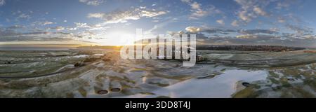 Aus der Vogelperspektive auf die Sonne, die einen goldenen Glanz über dem schneebedeckten Golfplatz und Hotel in St Andrews, Schottland, Großbritannien ausstrahlt. Stockfoto