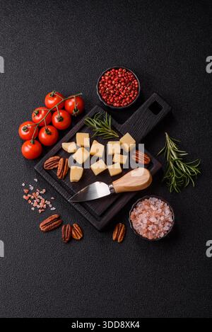 Gewürfelter Cheddar, Gouda oder Parmesankäse auf einem Schneidebrett. Gewürfelter Käse als Lebensmittelhintergrund für Ihr Design Stockfoto