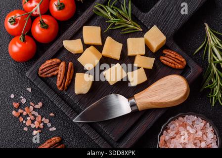 Gewürfelter Cheddar, Gouda oder Parmesankäse auf einem Schneidebrett. Gewürfelter Käse als Lebensmittelhintergrund für Ihr Design Stockfoto