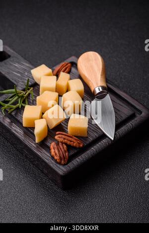 Gewürfelter Cheddar, Gouda oder Parmesankäse auf einem Schneidebrett. Gewürfelter Käse als Lebensmittelhintergrund für Ihr Design Stockfoto