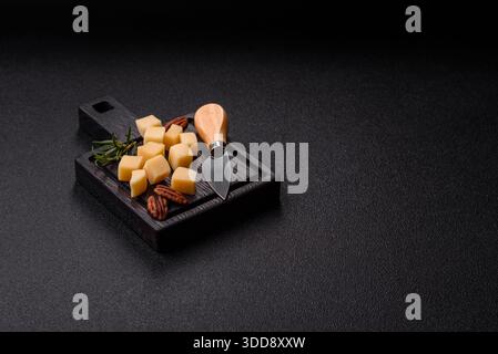 Gewürfelter Cheddar, Gouda oder Parmesankäse auf einem Schneidebrett. Gewürfelter Käse als Lebensmittelhintergrund für Ihr Design Stockfoto