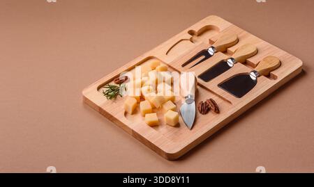 Gewürfelter Cheddar, Gouda oder Parmesankäse auf einem Schneidebrett. Gewürfelter Käse als Lebensmittelhintergrund für Ihr Design Stockfoto