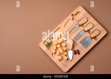 Gewürfelter Cheddar, Gouda oder Parmesankäse auf einem Schneidebrett. Gewürfelter Käse als Lebensmittelhintergrund für Ihr Design Stockfoto