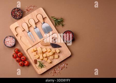 Gewürfelter Cheddar, Gouda oder Parmesankäse auf einem Schneidebrett. Gewürfelter Käse als Lebensmittelhintergrund für Ihr Design Stockfoto