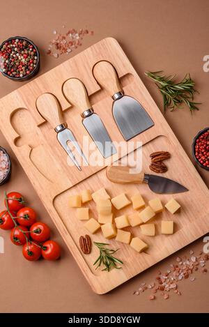 Gewürfelter Cheddar, Gouda oder Parmesankäse auf einem Schneidebrett. Gewürfelter Käse als Lebensmittelhintergrund für Ihr Design Stockfoto