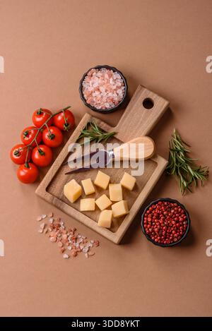 Gewürfelter Cheddar, Gouda oder Parmesankäse auf einem Schneidebrett. Gewürfelter Käse als Lebensmittelhintergrund für Ihr Design Stockfoto