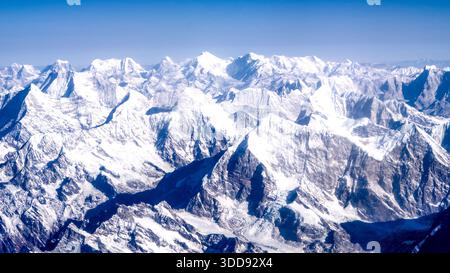 Riesige schneebedeckte Gipfel des Himalaya erstrecken sich unter einem klaren blauen Himmel und bieten einen atemberaubenden Blick auf den Berg Everest. Stockfoto