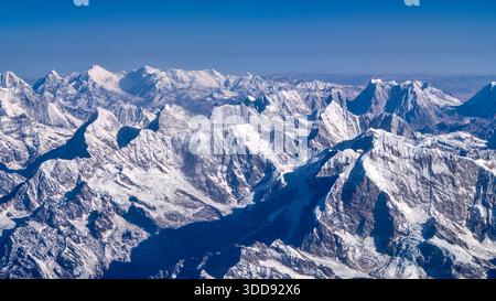 Die schneebedeckten Berge des Himalaya erstrecken sich unter einem klaren Himmel und bieten einen atemberaubenden Blick auf den Berg Everest. Stockfoto