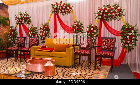 Festlich eingerichtetes Zimmer mit Blumenarrangements, Sofa und Stühlen für eine elegante Hochzeitsatmosphäre. Stockfoto