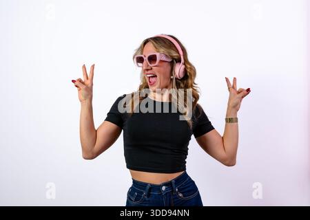 Frau, die Musik hört, Freude ausdrückt und enthusiastische Handgesten macht Stockfoto