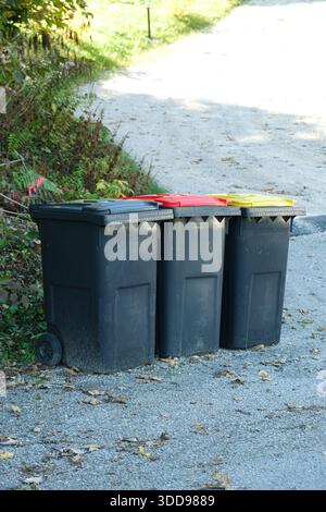 Müllsortierung in Europa. Mülltonnen mit bunten Deckeln für verschiedene Müllarten Stockfoto