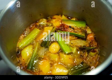 Eine Gemüsebrühe wird durch langes Kochen verschiedener Gemüsesorten mit Gewürzen und Kräutern in Wasser hergestellt, um eine Brühe zu erhalten, die als Gemüse verwendet werden kann Stockfoto