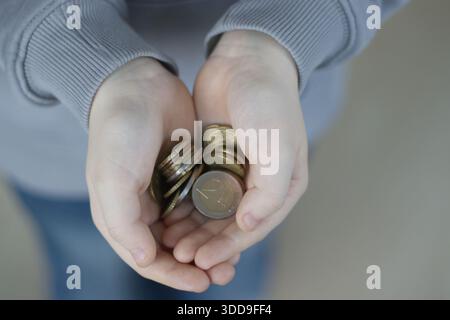 Euro-Münzen in Kinderhänden, Nahaufnahme Stockfoto