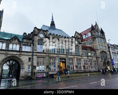 Manchester, Großbritannien - 06. Dezember 2025: Historisches gotisches Rathaus in Manchester, Großbritannien, mit bogenförmigem Eingang und großen Fenstern heute. Stockfoto