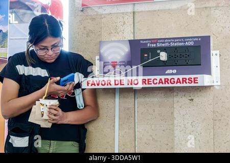 Puebla Mexico, CAPU Central de Autobus de Puebla Bushaltestelle, Erwachsene Frau weiblich, hispanische Latino mexikanisch, Passagiere warten, Smartphone-SMS verwenden, Char Stockfoto