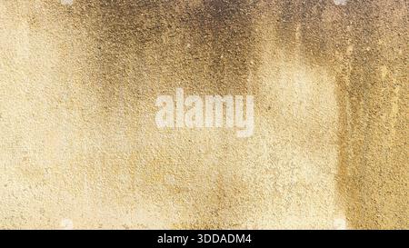 Gritty verwitterte Betonwand-Textur mit gelber Farbe und dunkler Form Flecken industriellen Grunge Hintergrund für architektonische Design oder Overlay Stockfoto