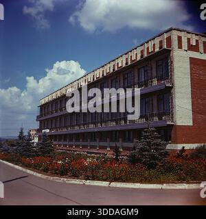 Slawjansk, Ukraine, UdSSR, 1980er Jahre Die Außenansicht des Bogatyr Preventoriums (Kurort), das dem Produktionsverband Khimprom gehört. Das Gebäude verfügt über eine typische sowjetische Resortarchitektur und liegt in einer grünen Zone, wahrscheinlich in der Nähe der Salzseen. Diese Einrichtung bot medizinische Behandlung und Erholung für Chemiearbeiter und deren Familien, was die umfangreichen Sozialleistungen des Unternehmens widerspiegelt. Das Archivbild zeigt die Infrastruktur des Gesundheitswesens und die Lebensqualität der Industriemitarbeiter in der friedlichen Donbass-Stadt. Stockfoto