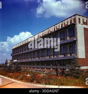 Slawjansk, Ukraine, UdSSR, 1980er Jahre Die Außenansicht des Bogatyr Preventoriums (Kurort), das dem Produktionsverband Khimprom gehört. Das Gebäude verfügt über eine typische sowjetische Resortarchitektur und liegt in einer grünen Zone, wahrscheinlich in der Nähe der Salzseen. Diese Einrichtung bot medizinische Behandlung und Erholung für Chemiearbeiter und deren Familien, was die umfangreichen Sozialleistungen des Unternehmens widerspiegelt. Das Archivbild zeigt die Infrastruktur des Gesundheitswesens und die Lebensqualität der Industriemitarbeiter in der friedlichen Donbass-Stadt. Stockfoto