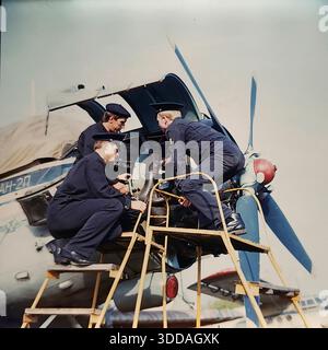 Slawjansk, Ukraine, UdSSR, 1980er Jahre Kadetten der Zivilluftfahrt-Technikschule (SATU) führen während der praktischen Ausbildung Wartungsarbeiten an einem Triebwerk der Antonov an-24 durch. Drei Studenten in dunkelblauen Uniformen, von links nach rechts als S.A. Kochetygov, Yu.L. identifiziert Metik und A.I. Kochevnikov untersuchen den Propellermechanismus von einer gelben Serviceplattform aus. Die offene Verkleidung zeigt interne Komponenten. Dieses Archivbild zeigt die rigorose technische Ausbildung und Vorbereitung von Luftfahrtspezialisten in der friedlichen sowjetischen Stadt. Stockfoto